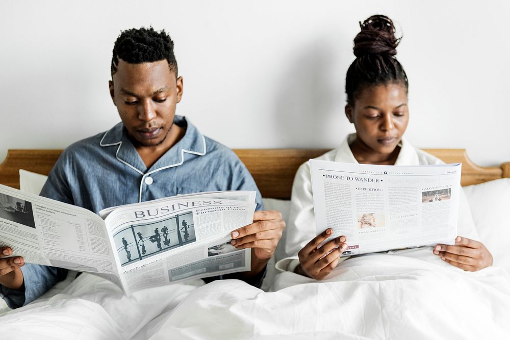 A happy couple reading in bed