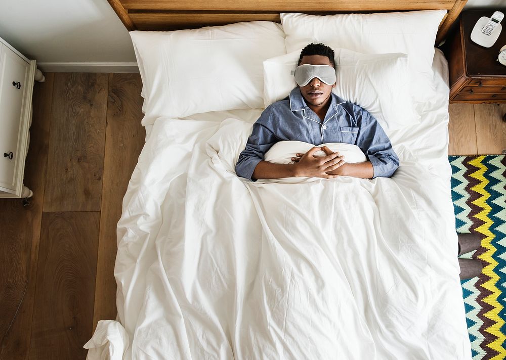 Guy wearing a mask sleeping in bed