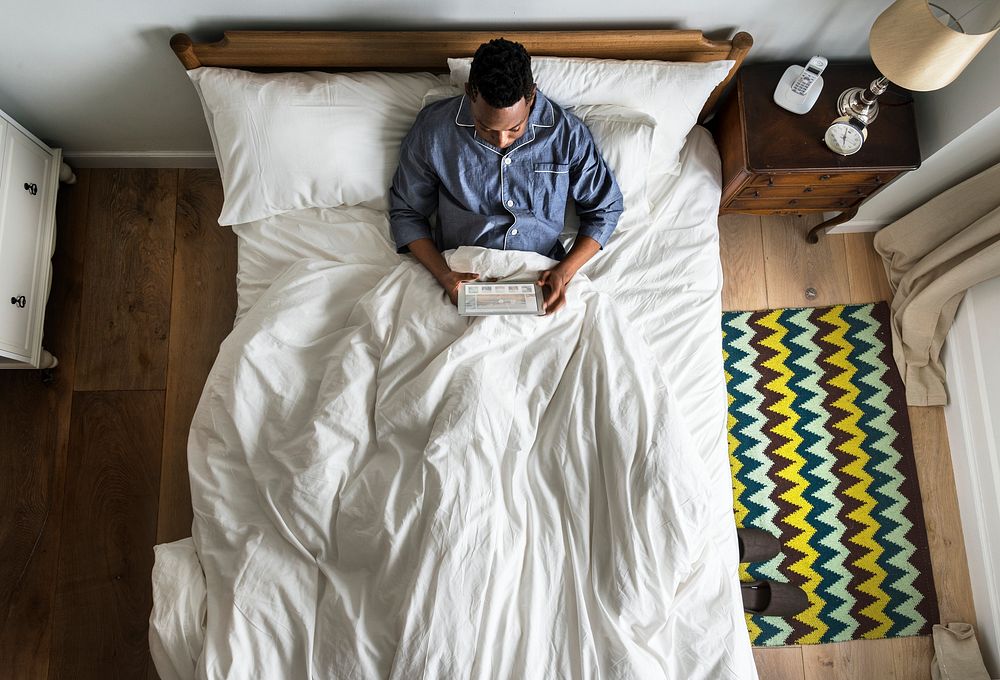 Man in bed using a digital device