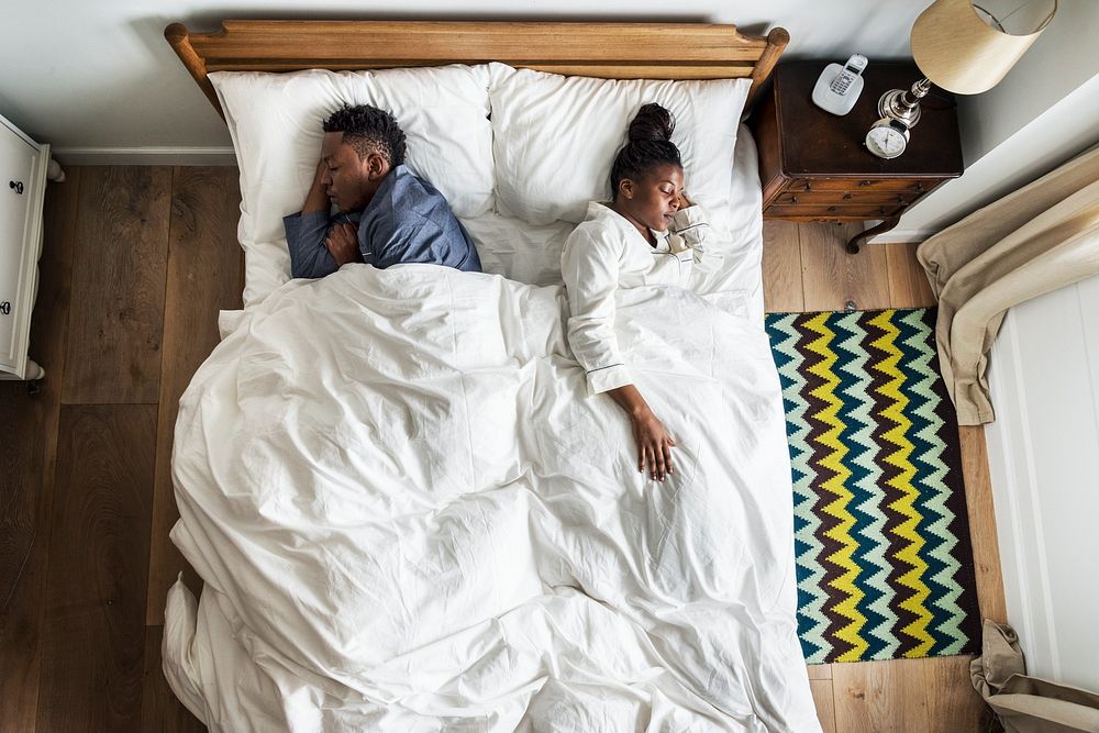 African American couple sleeping back to back