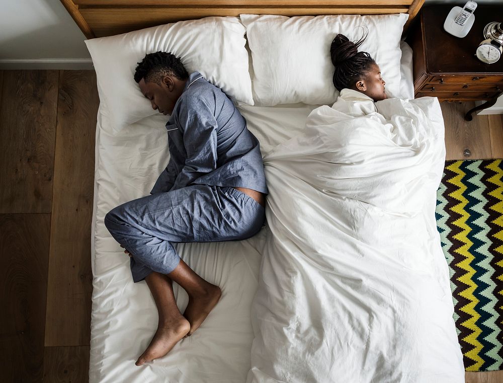 African American couple sleeping back to back