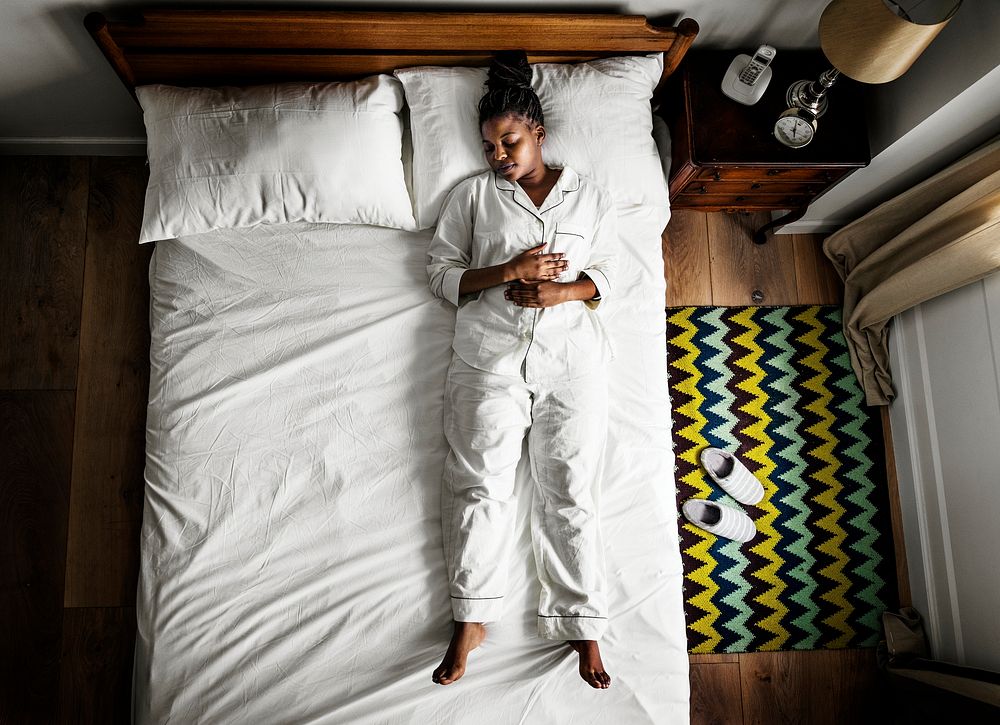 African American woman on bed sleeping alone