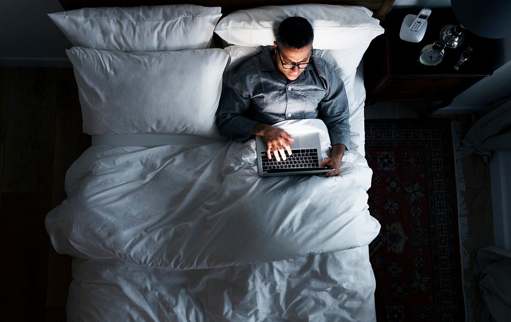 Man on bed using his laptop
