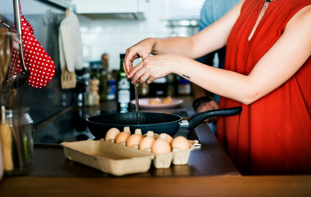 Caucasian woman coloking eggs in the kitchen