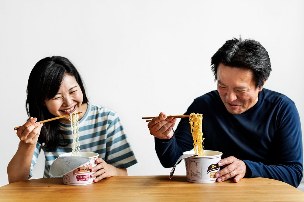 Asian couple eating instant noodles