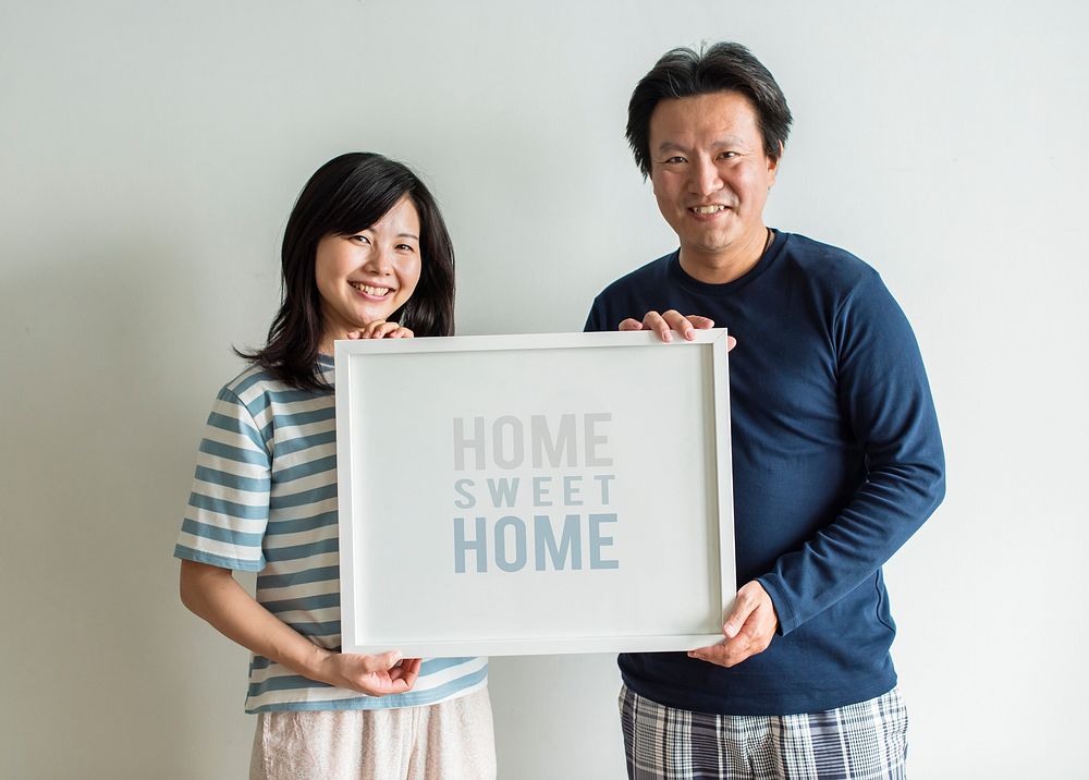 Asian couple holding photo frame together