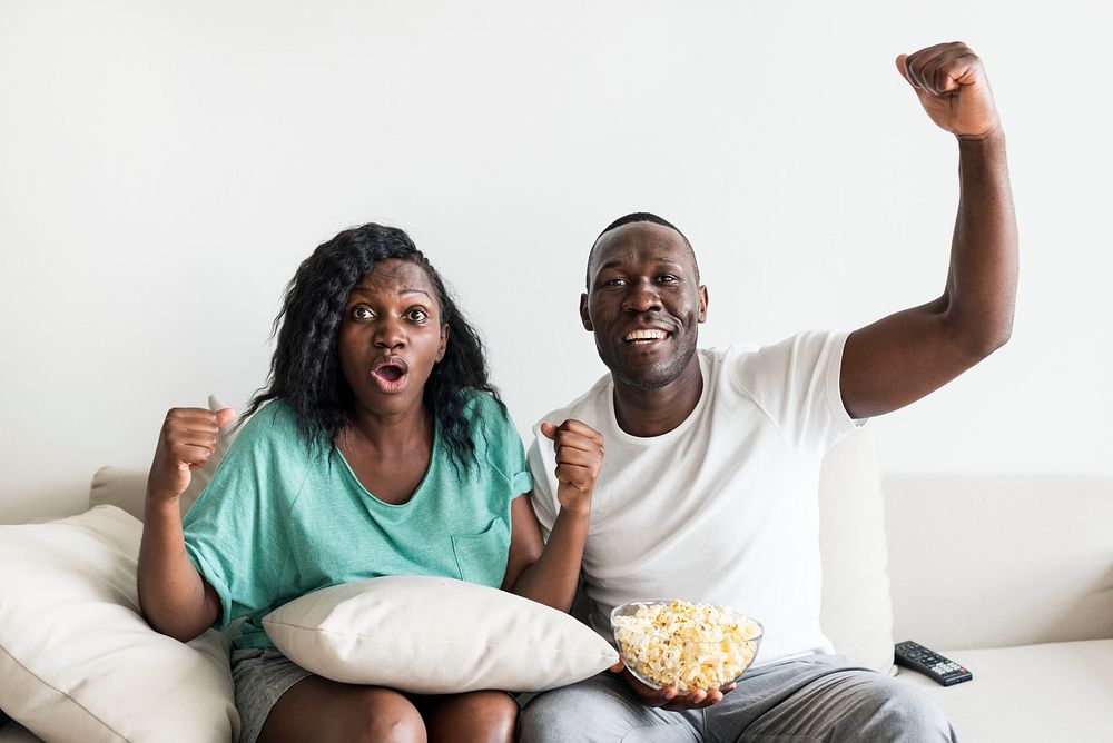 Black couple watching movie together at home