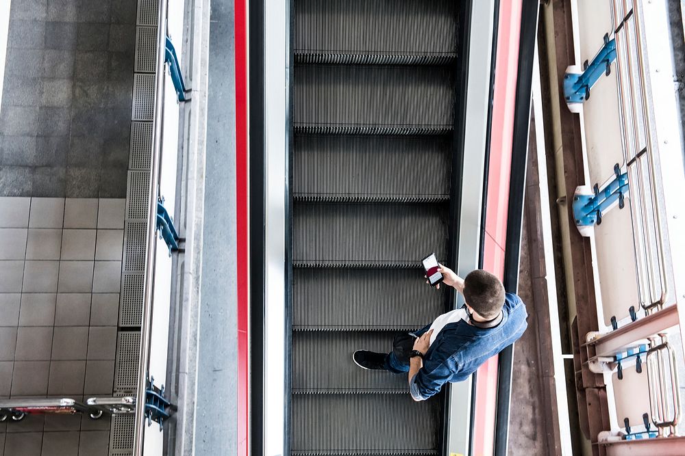 Man using a smartphone on the escalator