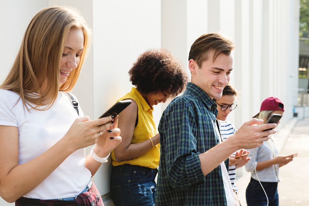 Friends using smartphones outdoors together | Premium Photo - rawpixel