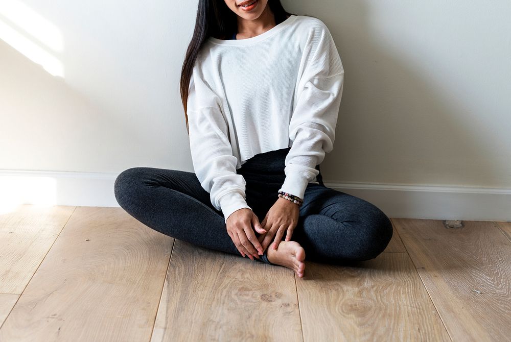 Asian woman sitting on wooden floor