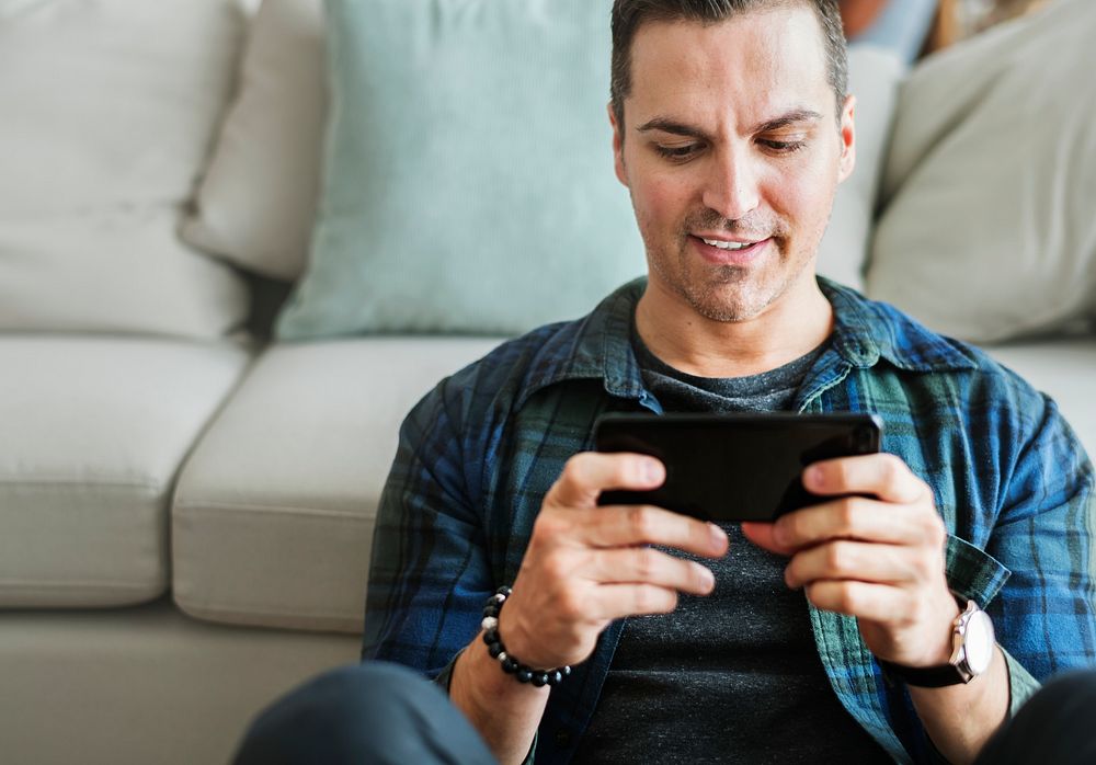 White man playing game in mobile phone