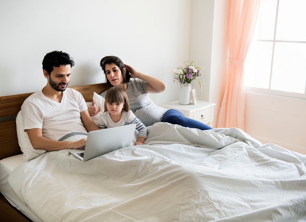 Pregnant family spending time together using a laptop