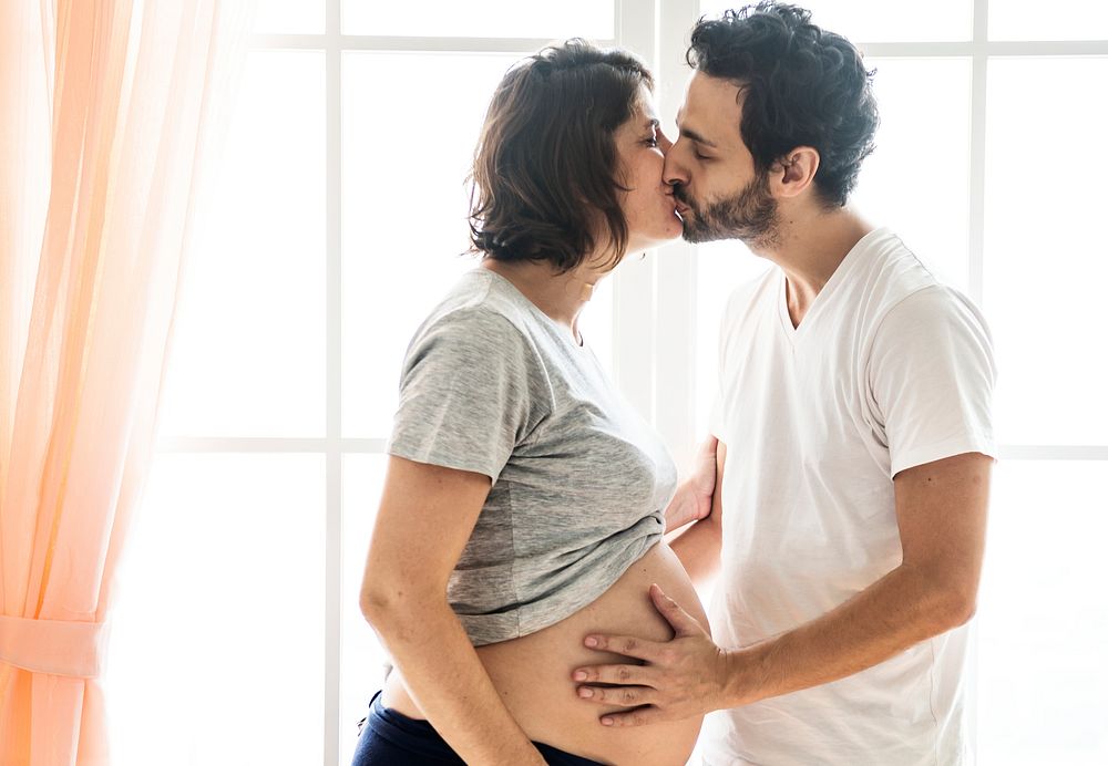 Pregnant woman and husband kissing