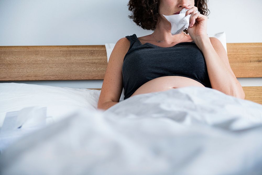 Sick pregnant woman on bed