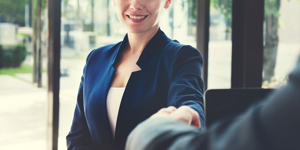 Businesswoman shaking hands with partner