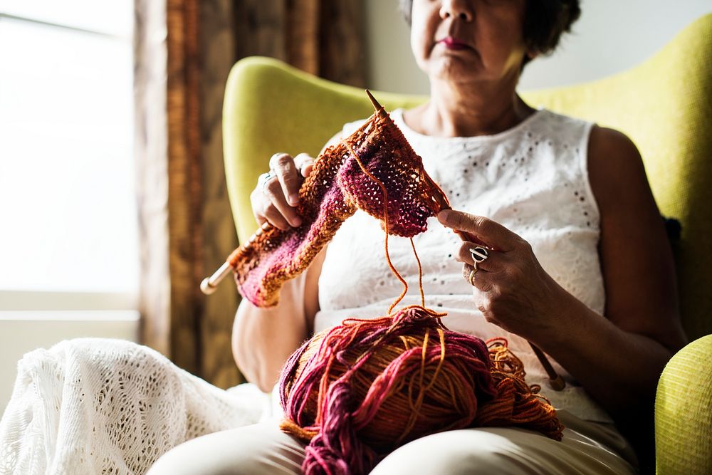 Senior woman knitting for hobby at home