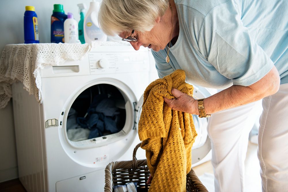 Elderly woman doing a laundry