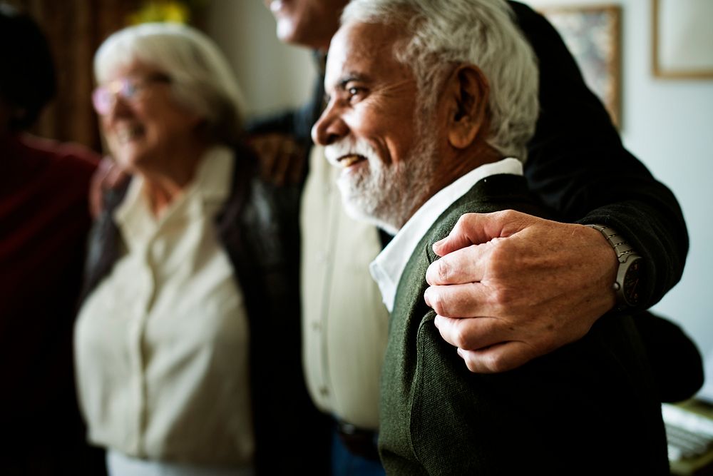 Senior adults arms around each other's shoulder