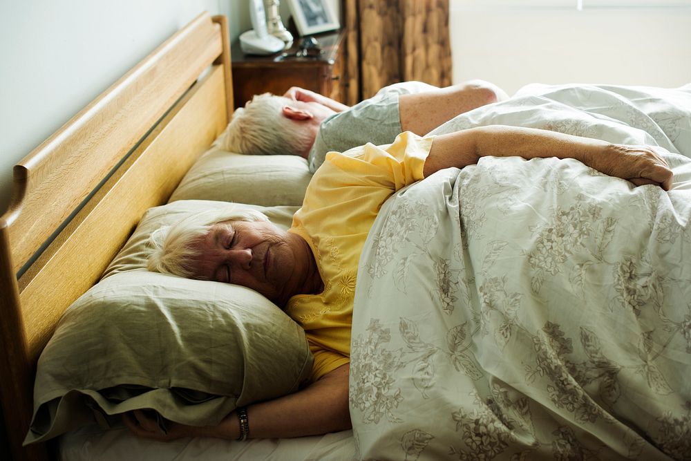 Elderly caucasian couple sleeping on the bed