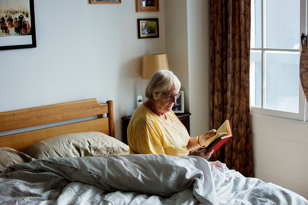 Senior woman reading on a bed