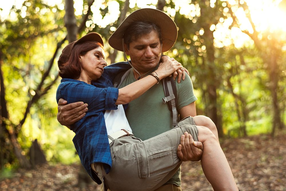 Man holding his partner up while trekking in the jungle