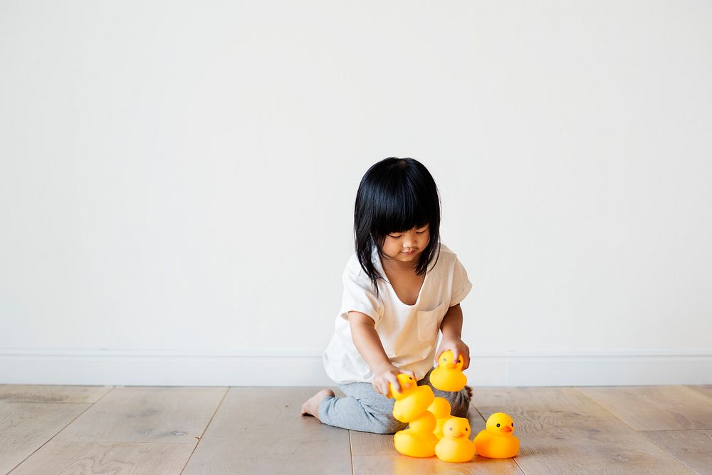 Young Asian girl playing with rubber ducks