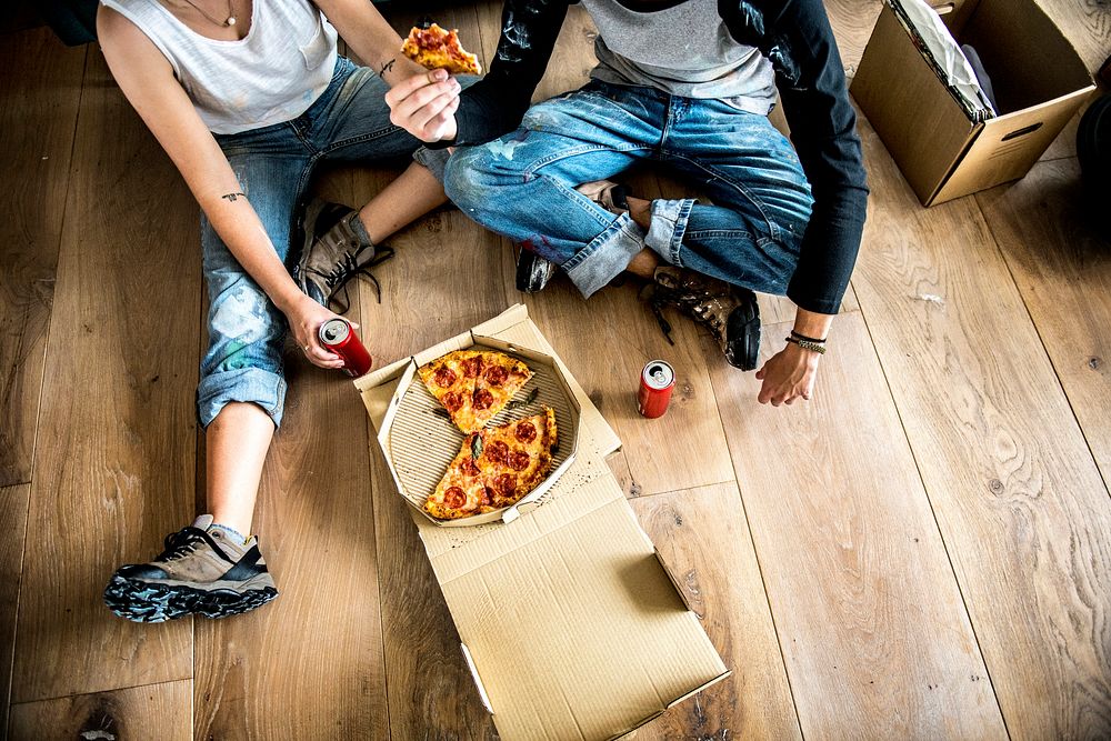 Couple moving into new house and eating pizza