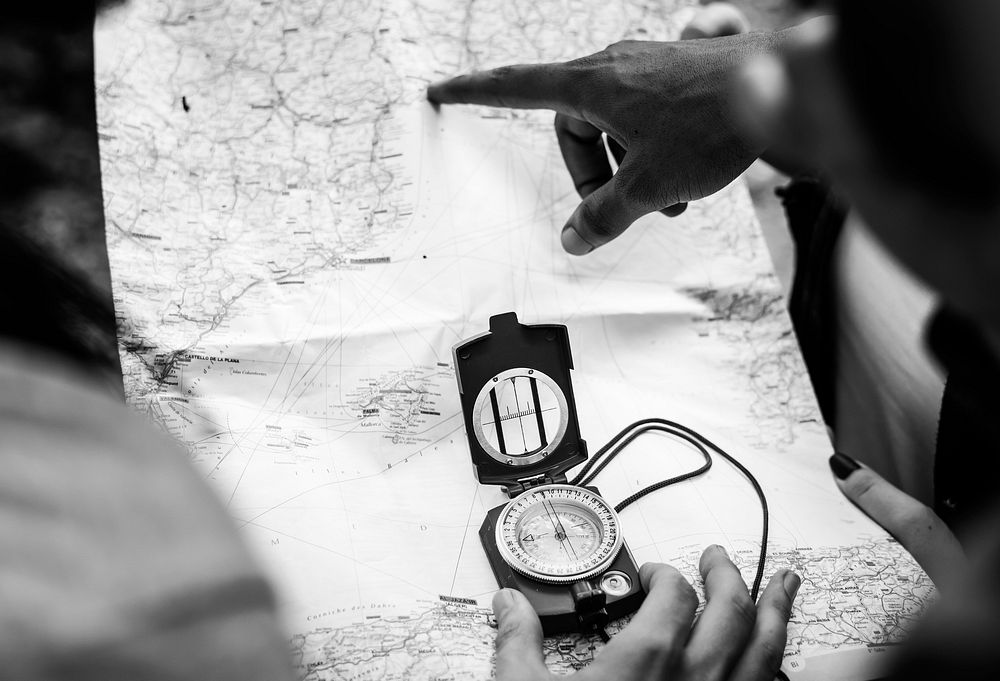 People using compass in black and white