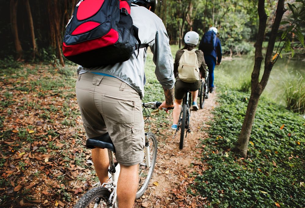 Active people ride mountain bike in the forest together