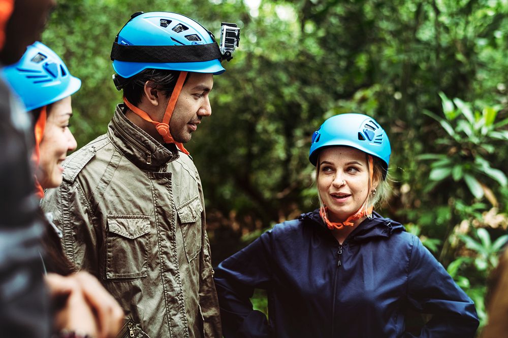 People with safety helmet trekking in a forest