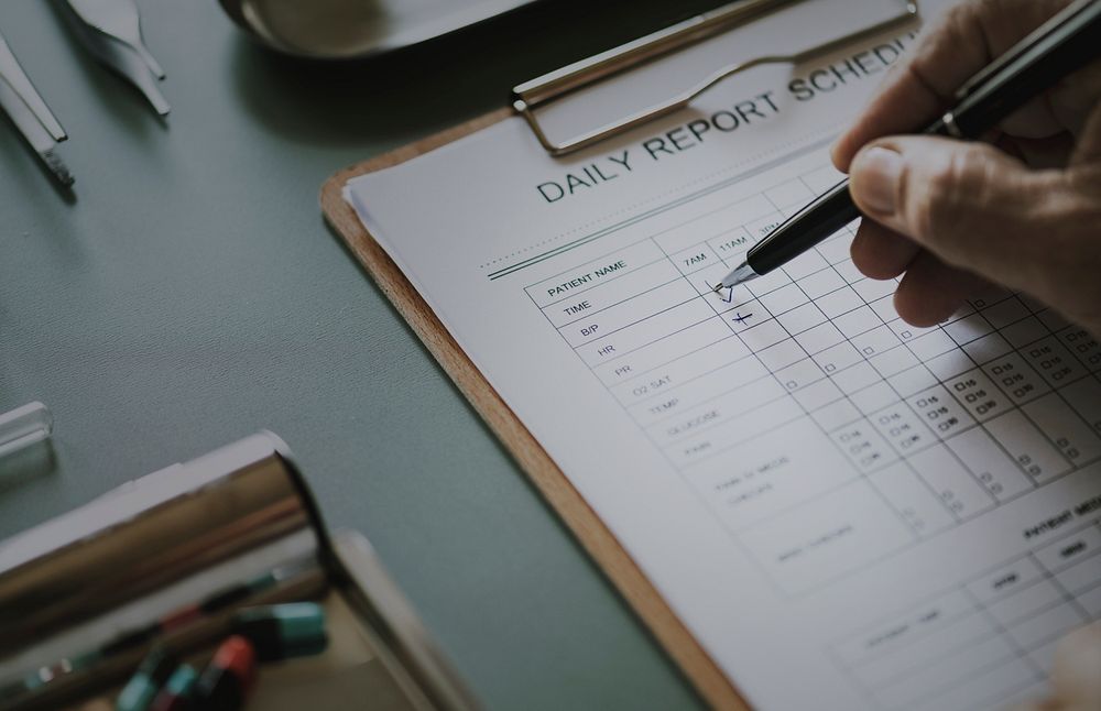 Closeup of doctor checking patient daily report checklist