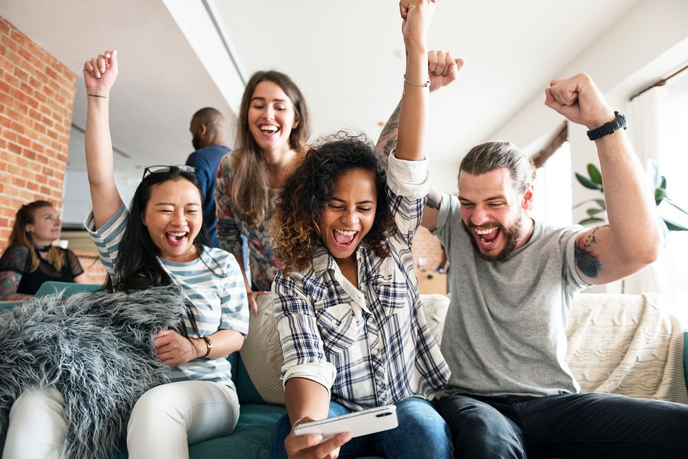 Group of diverse friends playing game on mobile phone