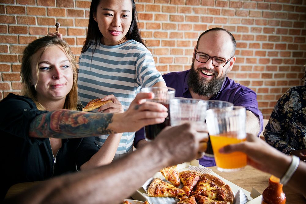 Friends eating pizza together at home