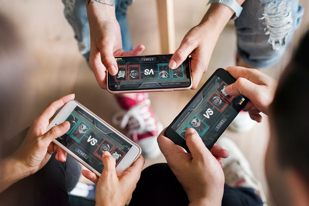Group of diverse friends playing game on mobile phone