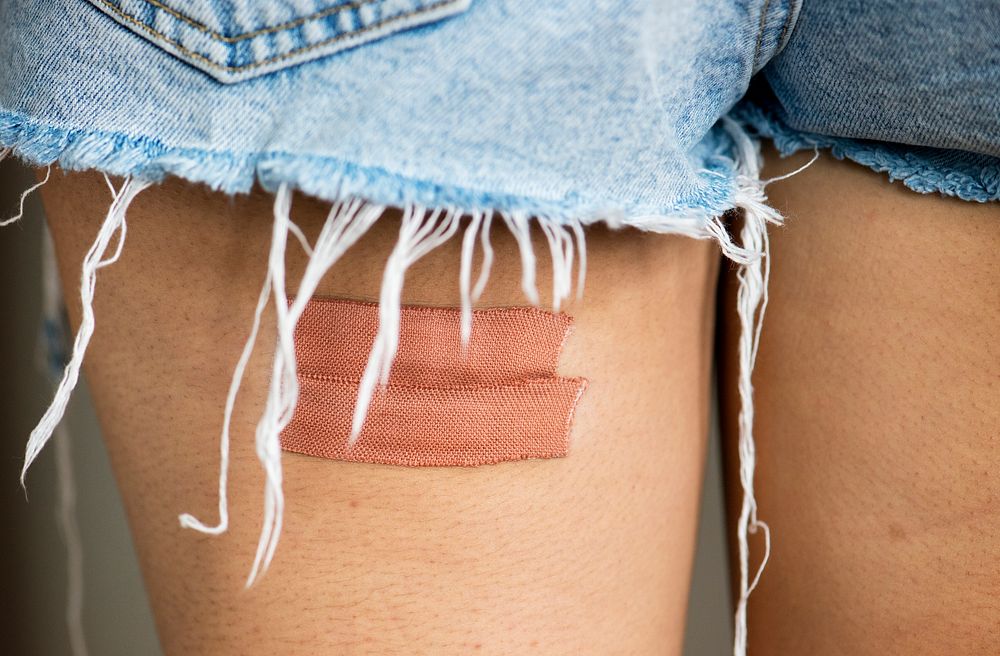 Closeup of a upper back thigh of a woman with bandage
