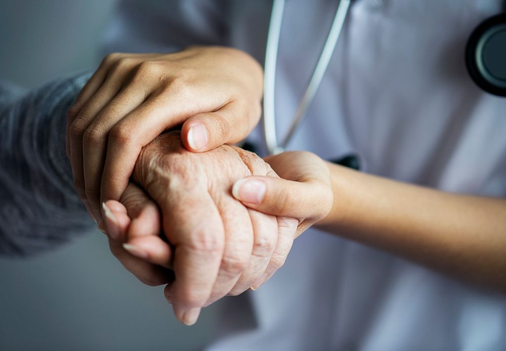 Doctor holding patient's hand, closeup photo