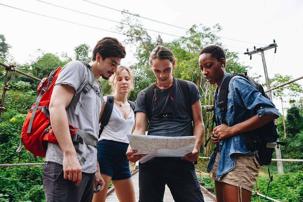 Group of friends looking at a map together travel and teamwork concept