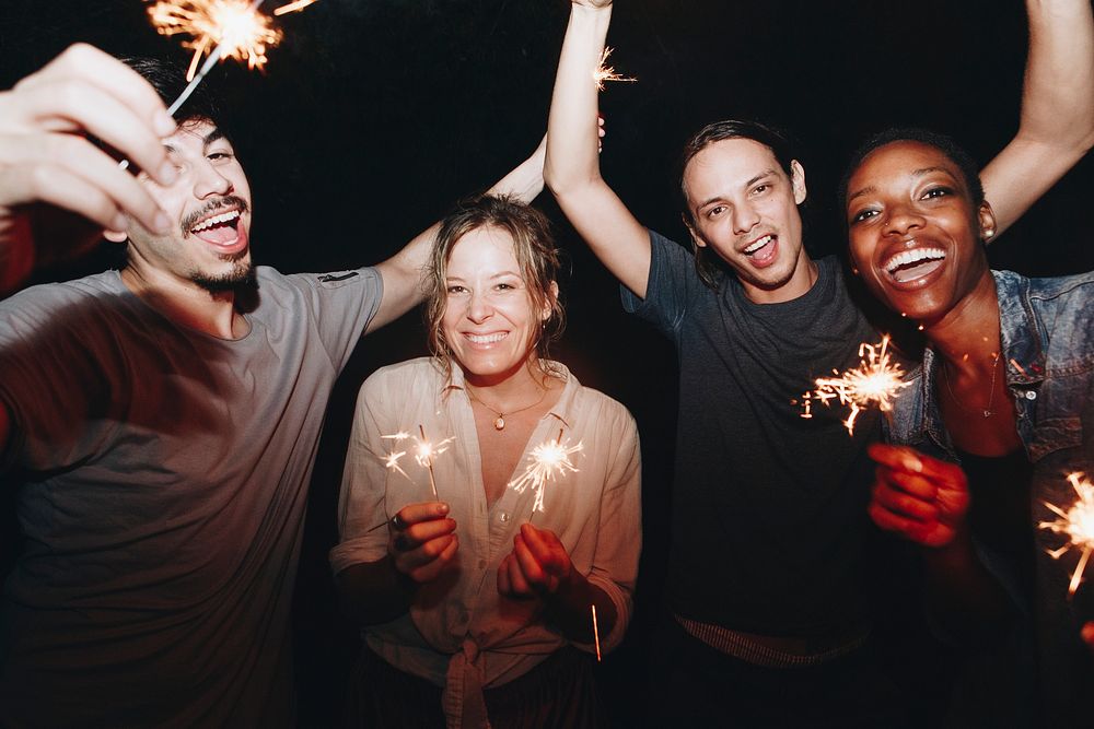 Friends having fun with sparklers in the night