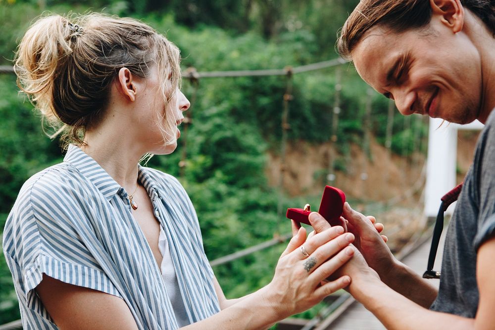Man proposing to his happy girlfriend outdoors love and marriage concept