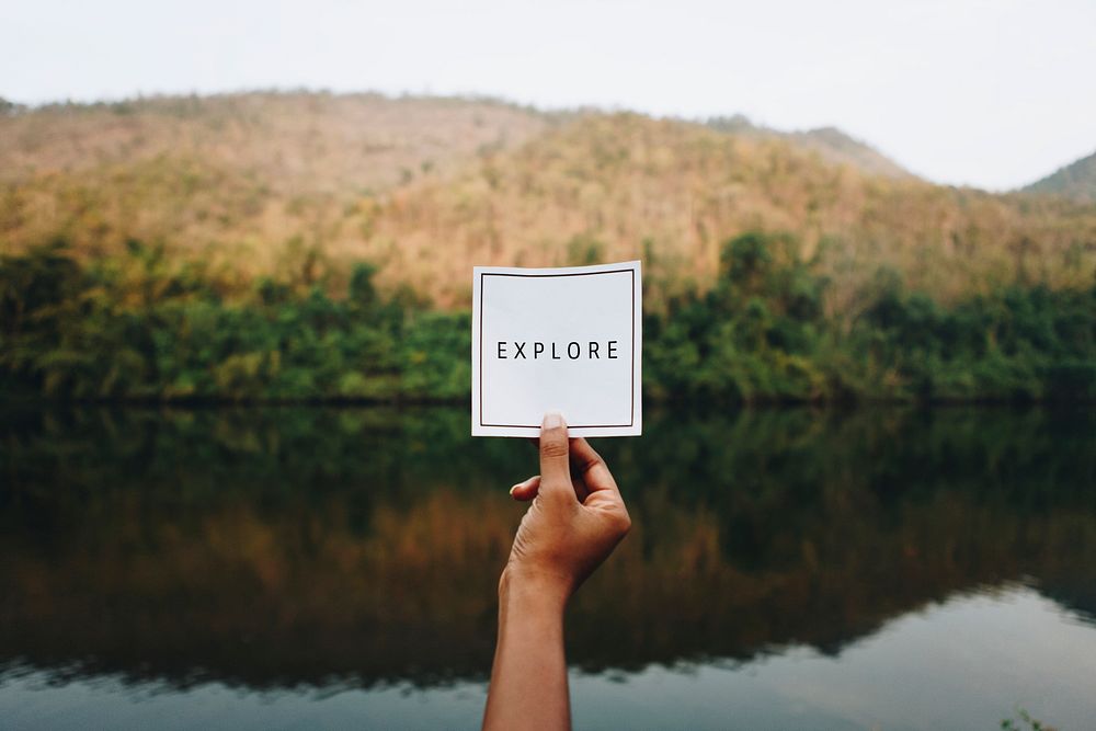 Woman holding up the word explore in nature