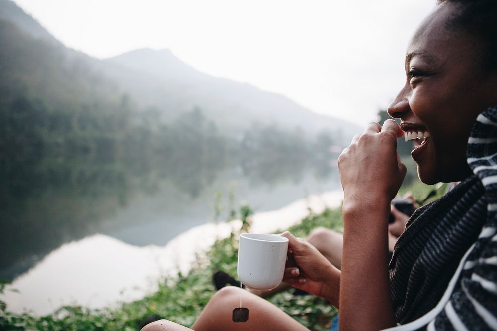 Woman enjoying morning coffee by a river