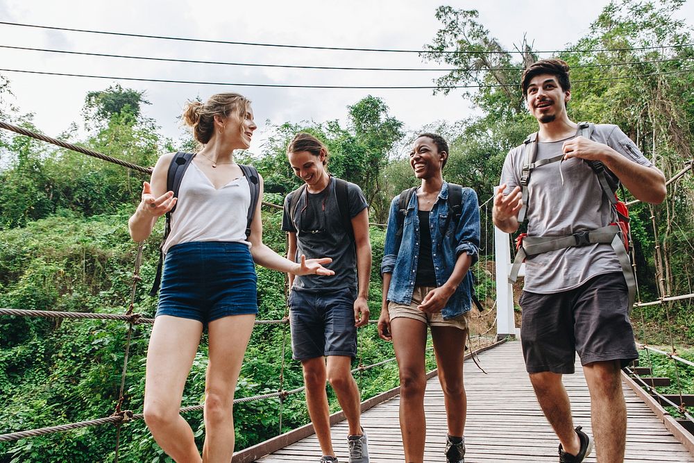 Group of friends walking on the bridge in a tropical countryside adventure and journey concept
