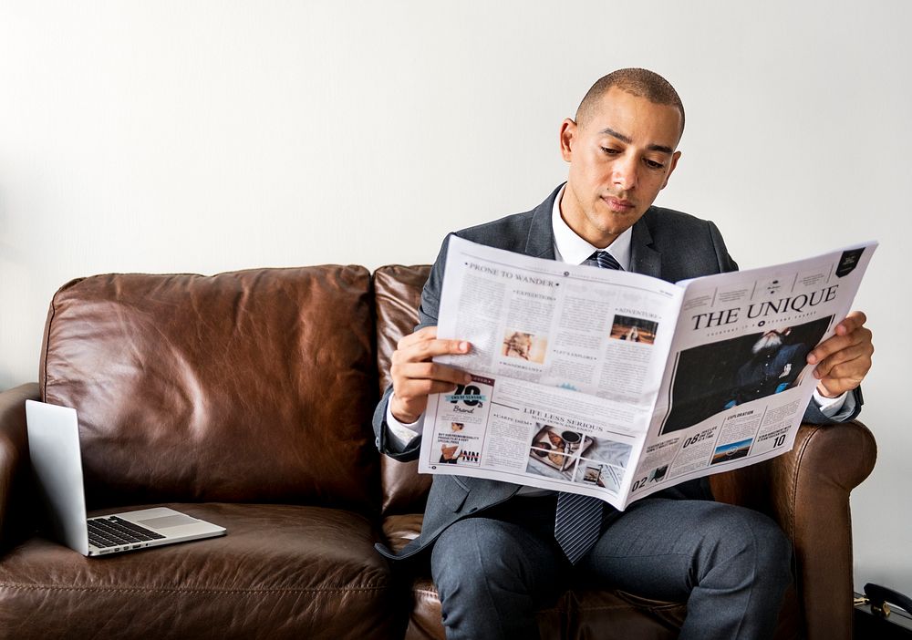 Businessman reading newspaper and having coffee
