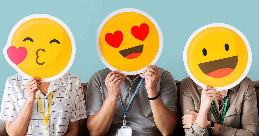 Cheerful people holding emoticon icon