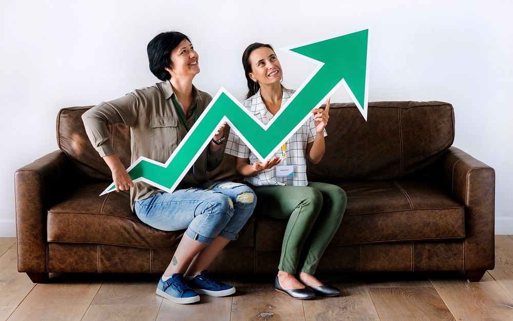 Women sitting on couch and holding statistics icon