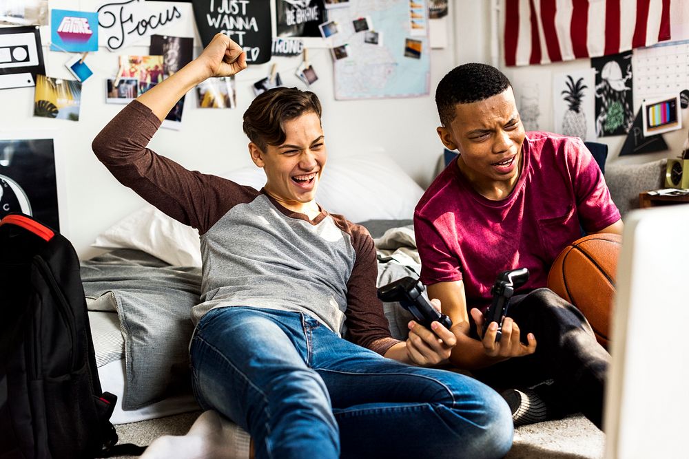 Teenage boys hanging out in a bedroom playing video games together