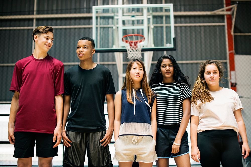 Group of young teenager friends on a basketball court standing in a row