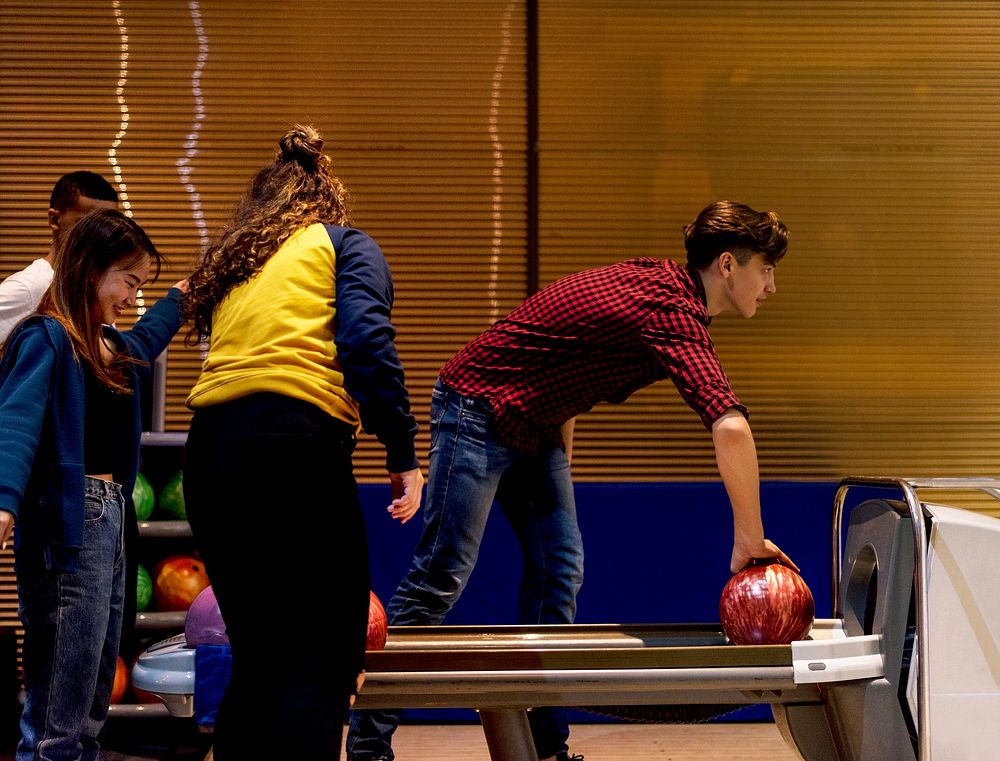 Caucasian boy picking up a bowling ball hobby and leisure concept