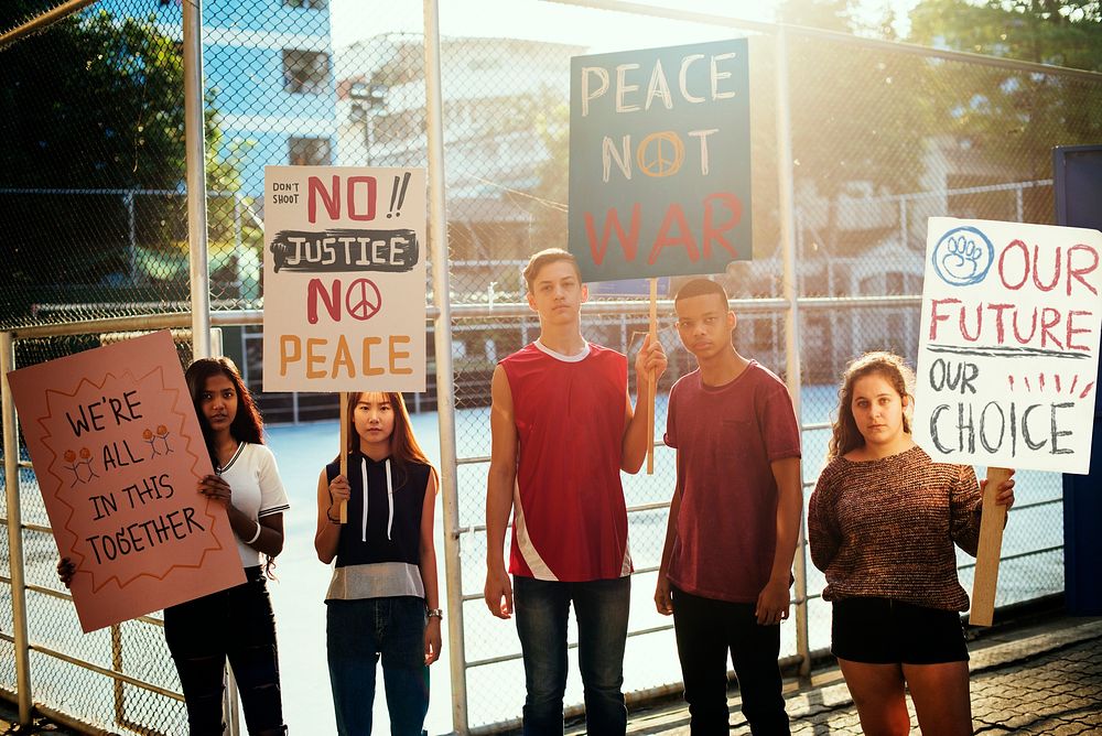 Group of teenagers protesting demonstration holding posters antiwar justice peace concept