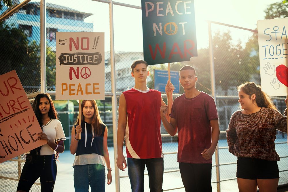 Group of teenagers protesting demonstration holding posters antiwar justice peace concept